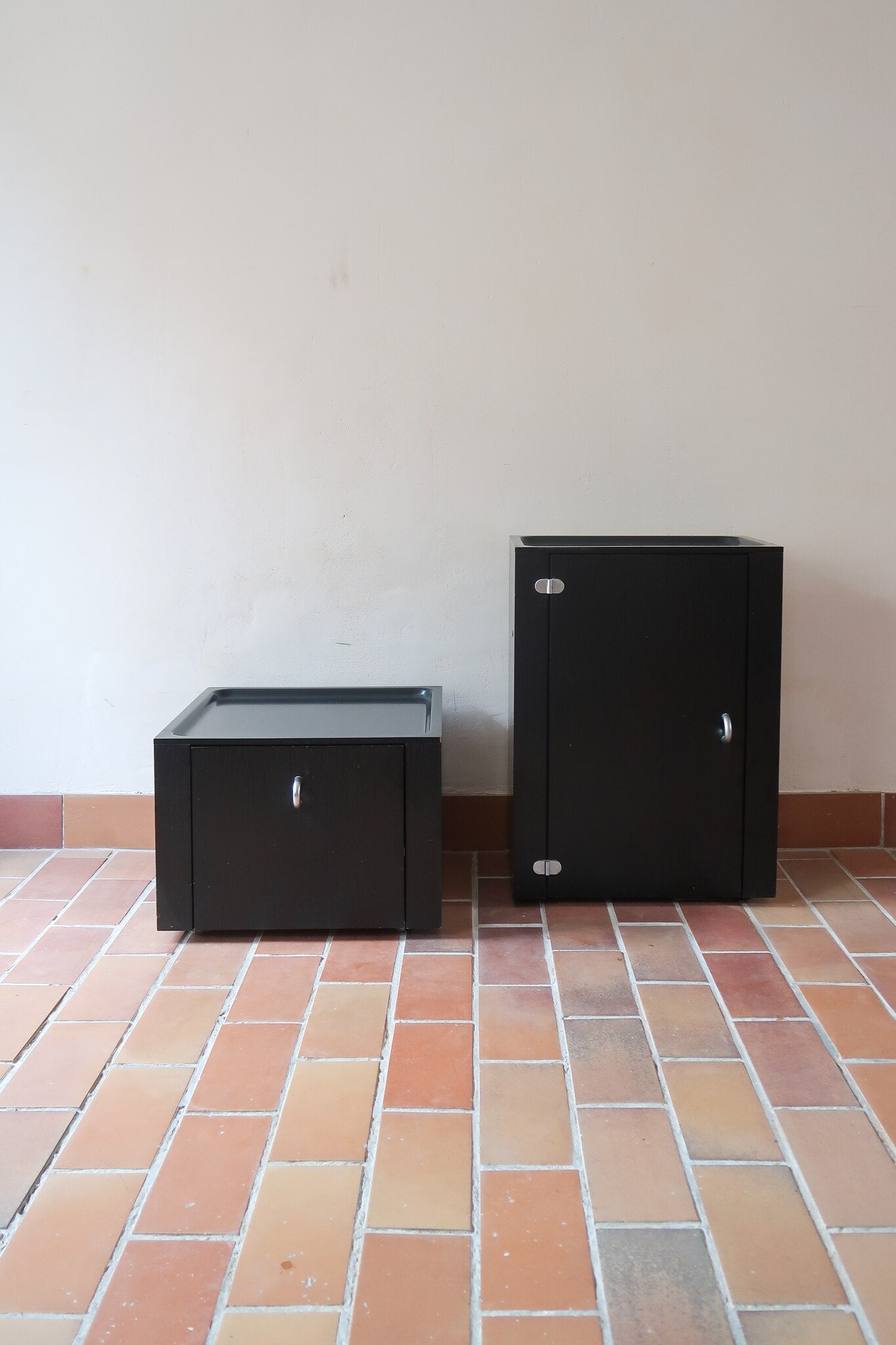 Duo de caissons vintage Roche Bobois années 90, bois laqué noir, module haut à abattant et module cube à porte, poignées chromées encastrées, intérieur laqué blanc