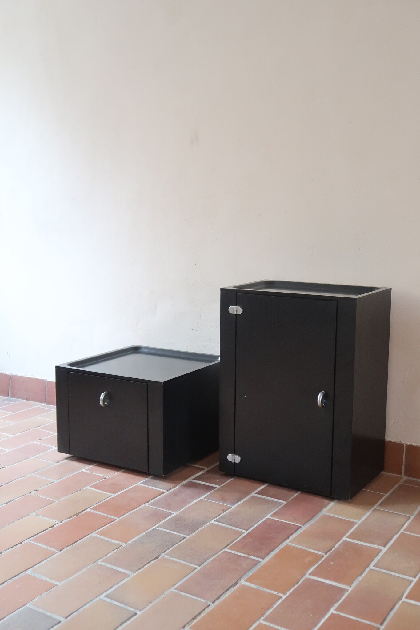 Duo de caissons vintage Roche Bobois années 90, bois laqué noir, module haut à abattant et module cube à porte, poignées chromées encastrées, intérieur laqué blanc