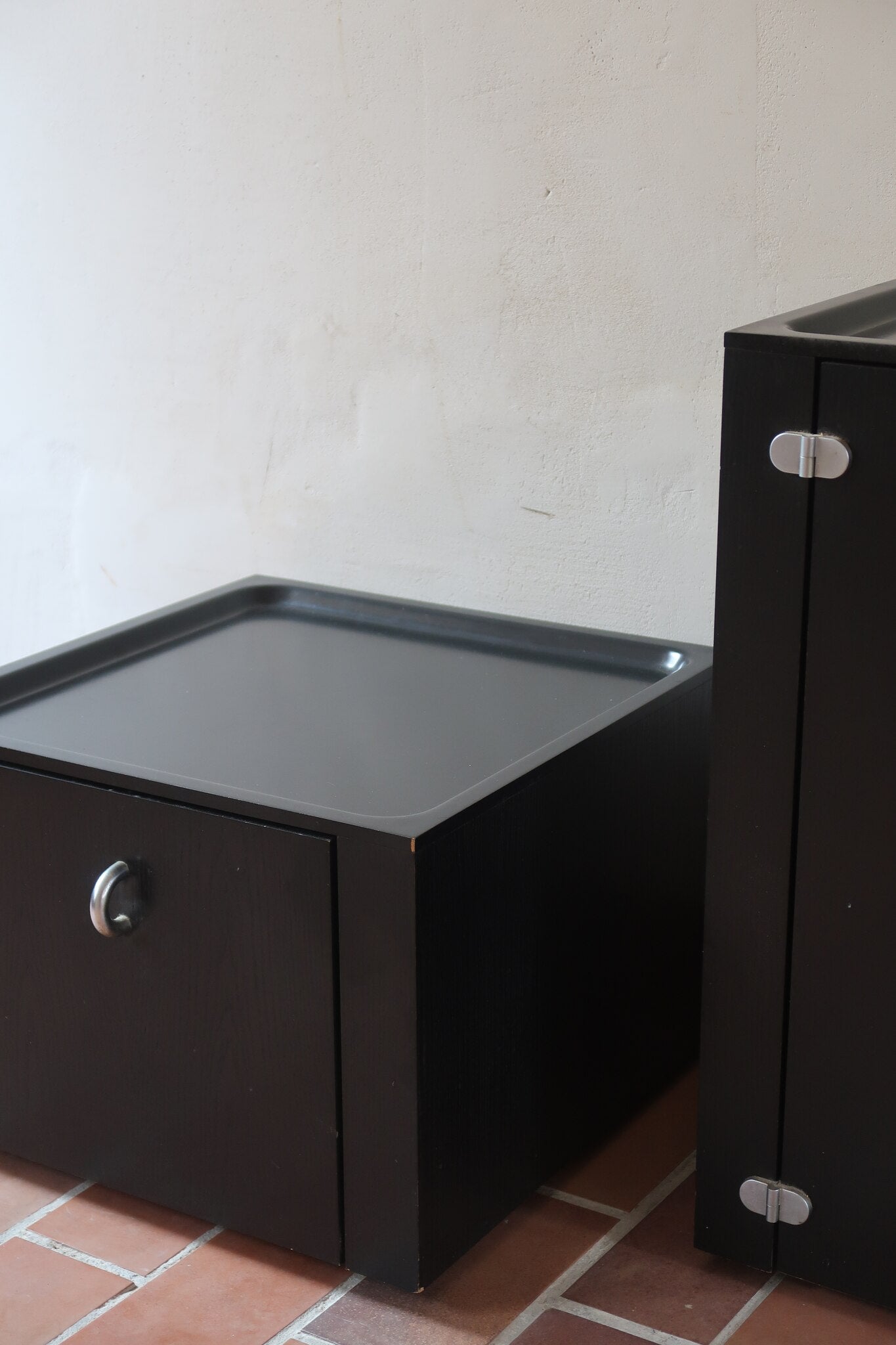 Duo de caissons vintage Roche Bobois années 90, bois laqué noir, module haut à abattant et module cube à porte, poignées chromées encastrées, intérieur laqué blanc