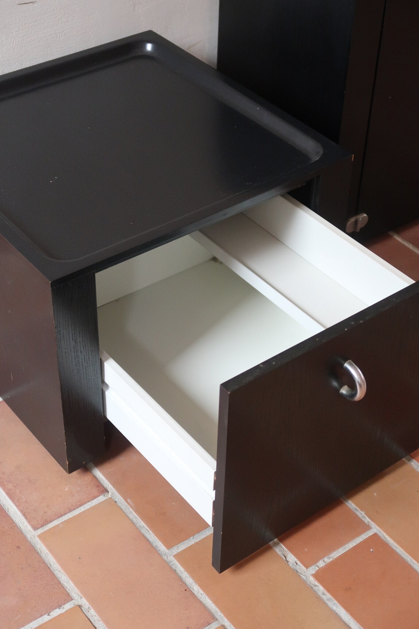 Duo de caissons vintage Roche Bobois années 90, bois laqué noir, module haut à abattant et module cube à porte, poignées chromées encastrées, intérieur laqué blanc