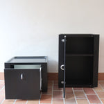 Duo de caissons vintage Roche Bobois années 90, bois laqué noir, module haut à abattant et module cube à porte, poignées chromées encastrées, intérieur laqué blanc