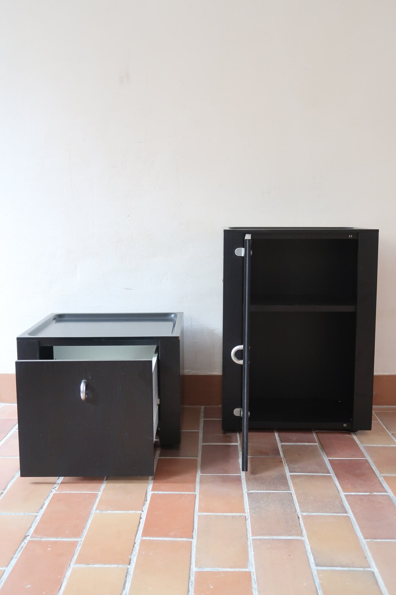 Duo de caissons vintage Roche Bobois années 90, bois laqué noir, module haut à abattant et module cube à porte, poignées chromées encastrées, intérieur laqué blanc