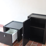 Duo de caissons vintage Roche Bobois années 90, bois laqué noir, module haut à abattant et module cube à porte, poignées chromées encastrées, intérieur laqué blanc