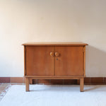 buffet vintage en bois clair années 60 deux portes avec poignées rondes et intérieur ouvert sans étagère