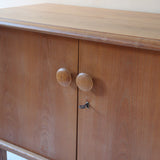 buffet vintage en bois clair années 60 deux portes avec poignées rondes et intérieur ouvert sans étagère