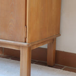 buffet vintage en bois clair années 60 deux portes avec poignées rondes et intérieur ouvert sans étagère