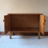 buffet vintage en bois clair années 60 deux portes avec poignées rondes et intérieur ouvert sans étagère
