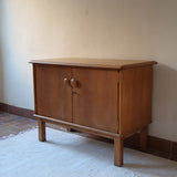 buffet vintage en bois clair années 60 deux portes avec poignées rondes et intérieur ouvert sans étagère