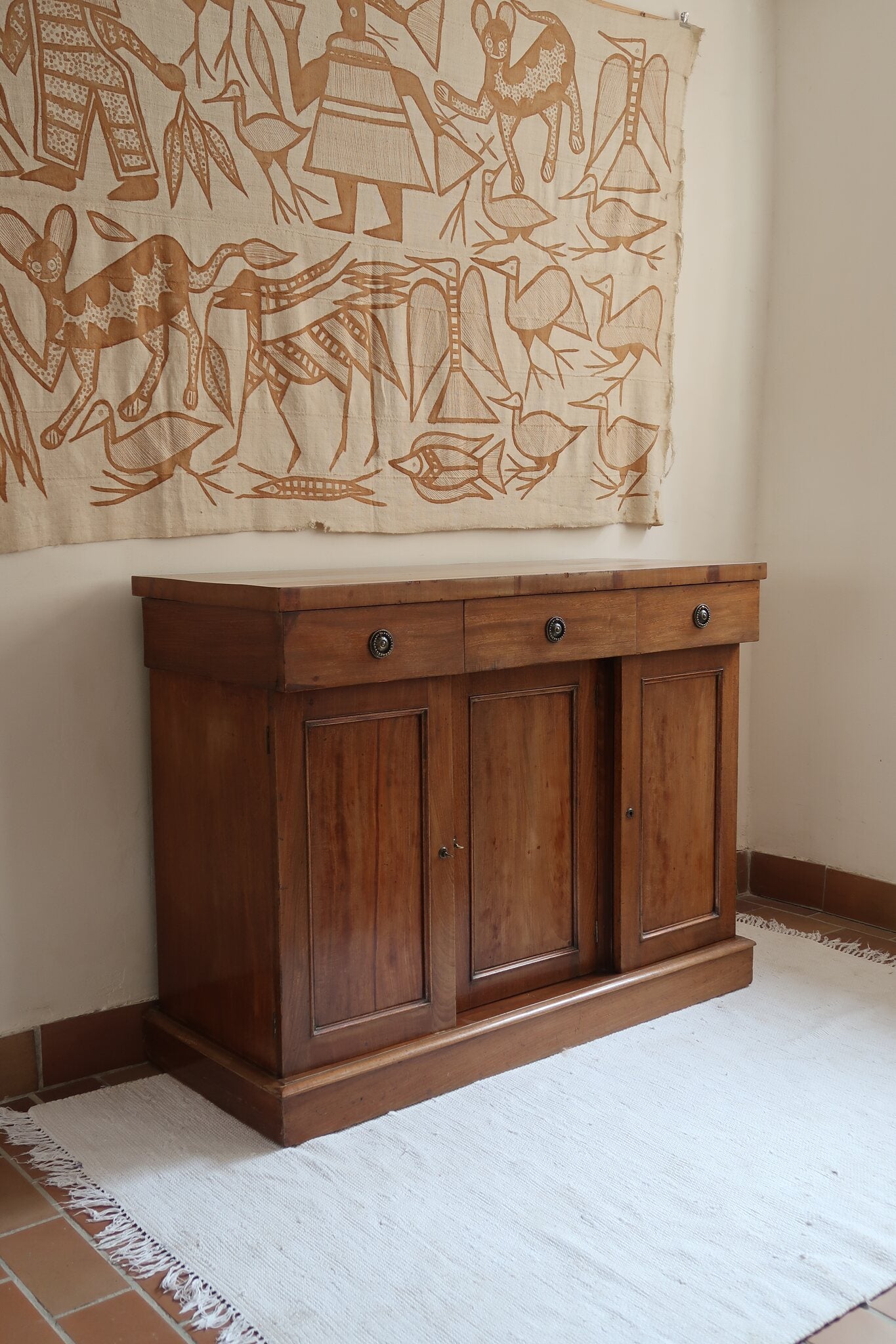 Buffet ancien vintage en bois de noyer massif, années 30, trois tiroirs en ceinture à poignées rondes en laiton, trois portes à panneaux moulurés, base à plinthe pleine, compartiment intérieur doublé de zinc