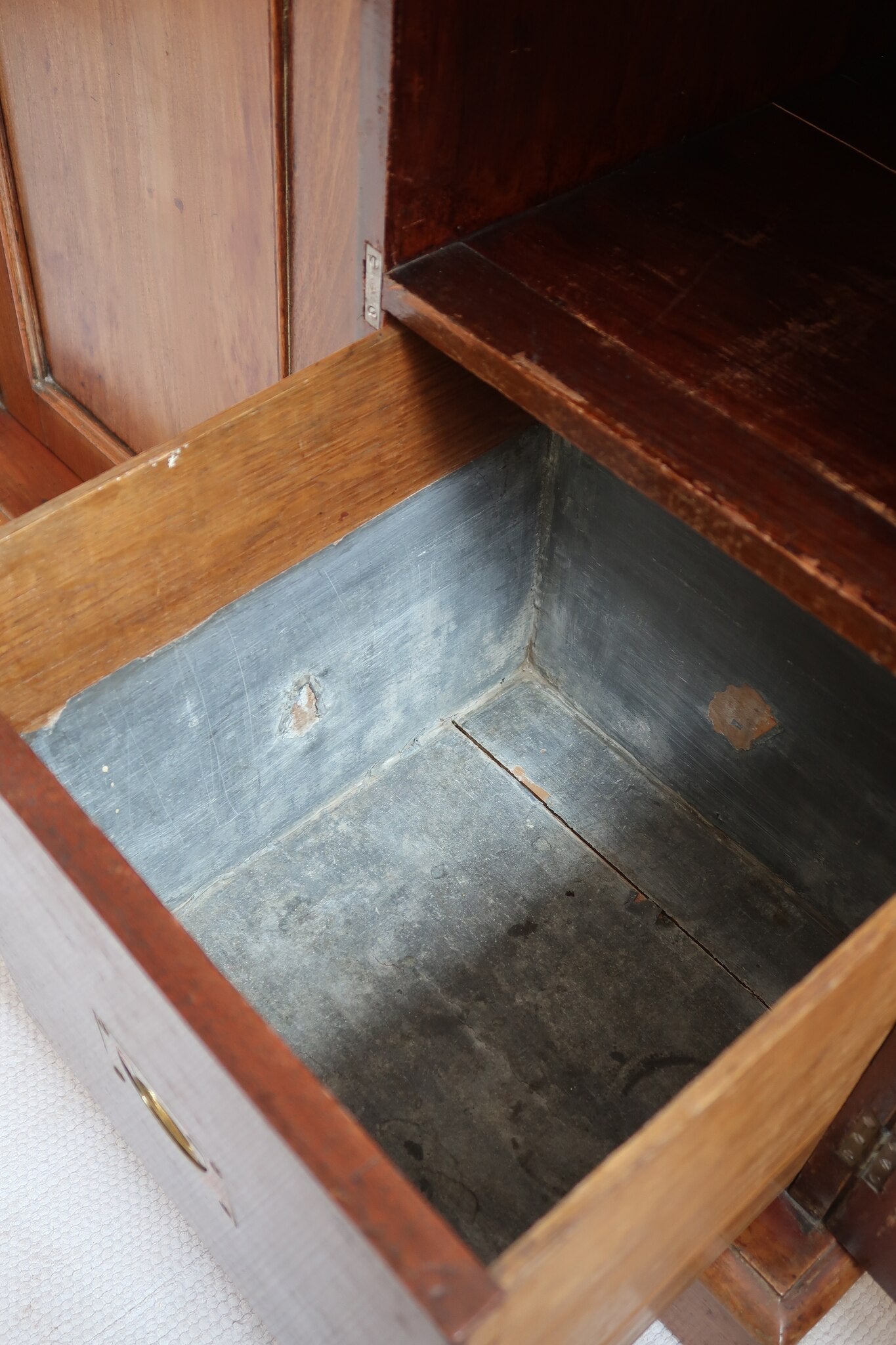 Buffet ancien vintage en bois de noyer massif, années 30, trois tiroirs en ceinture à poignées rondes en laiton, trois portes à panneaux moulurés, base à plinthe pleine, compartiment intérieur doublé de zinc