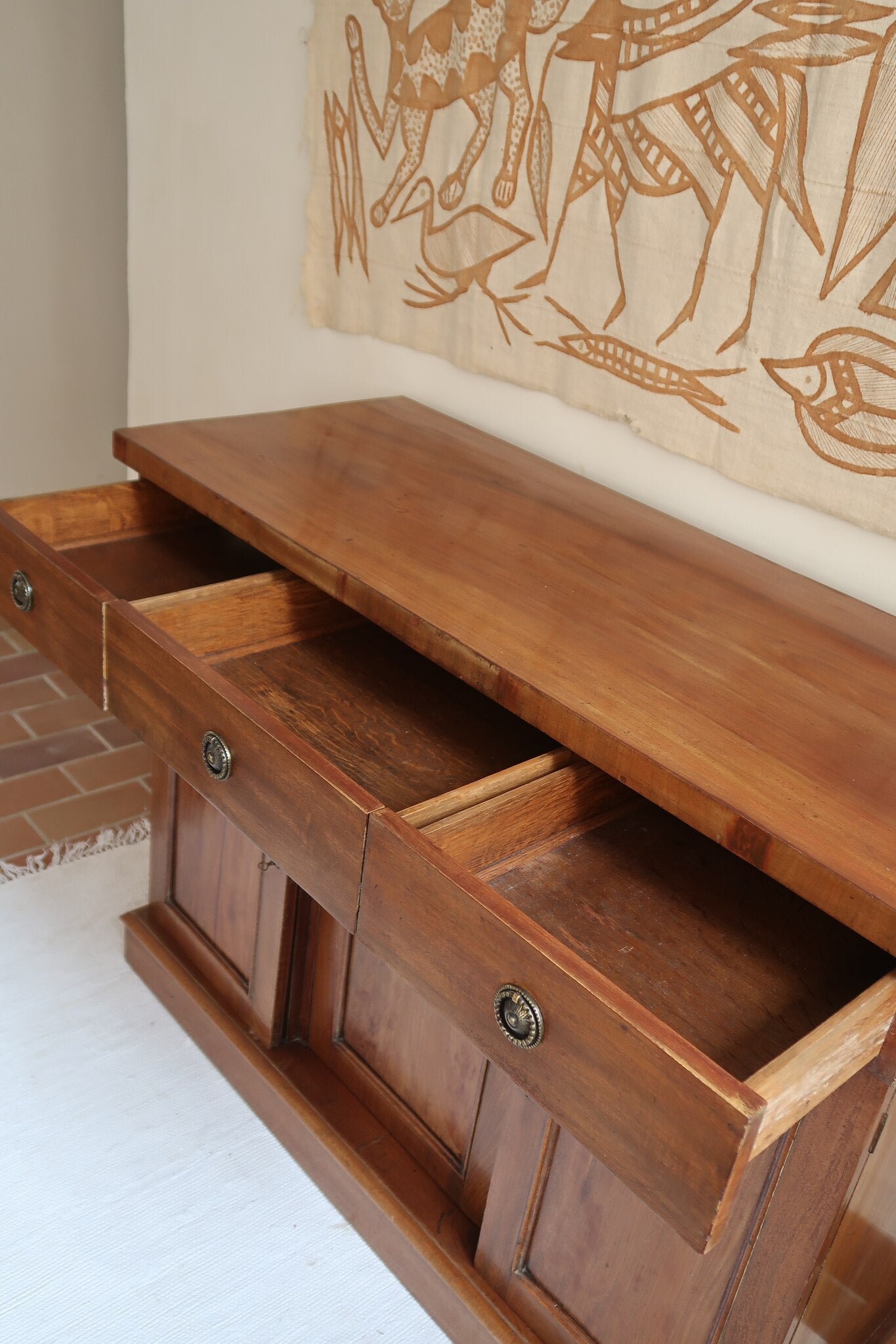 Buffet ancien vintage en bois de noyer massif, années 30, trois tiroirs en ceinture à poignées rondes en laiton, trois portes à panneaux moulurés, base à plinthe pleine, compartiment intérieur doublé de zinc