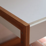 Bureau scandinave années 70 laqué blanc et bois clair, deux tiroirs à boutons ronds en bois, piétement à entretoise basse, lignes épurées mid-century