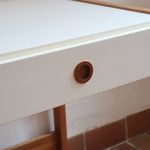 Bureau scandinave années 70 laqué blanc et bois clair, deux tiroirs à boutons ronds en bois, piétement à entretoise basse, lignes épurées mid-century
