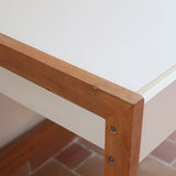 Bureau scandinave années 70 laqué blanc et bois clair, deux tiroirs à boutons ronds en bois, piétement à entretoise basse, lignes épurées mid-century