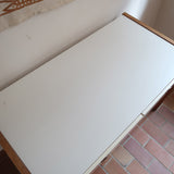 Bureau scandinave années 70 laqué blanc et bois clair, deux tiroirs à boutons ronds en bois, piétement à entretoise basse, lignes épurées mid-century