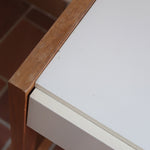 Bureau scandinave années 70 laqué blanc et bois clair, deux tiroirs à boutons ronds en bois, piétement à entretoise basse, lignes épurées mid-century