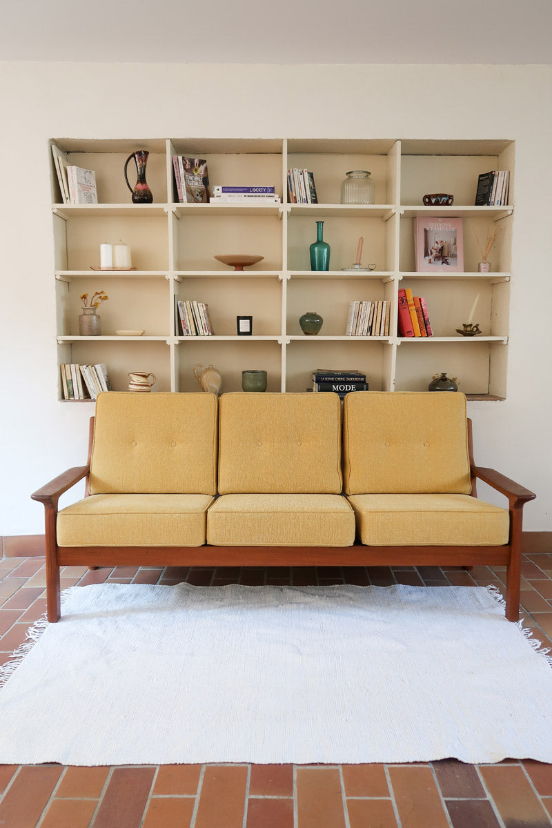 Canapé 3 places scandinave en teck des années 60 avec coussins en tissu jaune moutarde et structure type banquette.
