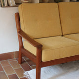 Canapé 3 places scandinave en teck des années 60 avec coussins en tissu jaune moutarde et structure type banquette.
