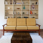 Canapé 3 places scandinave en teck des années 60 avec coussins en tissu jaune moutarde et structure type banquette.