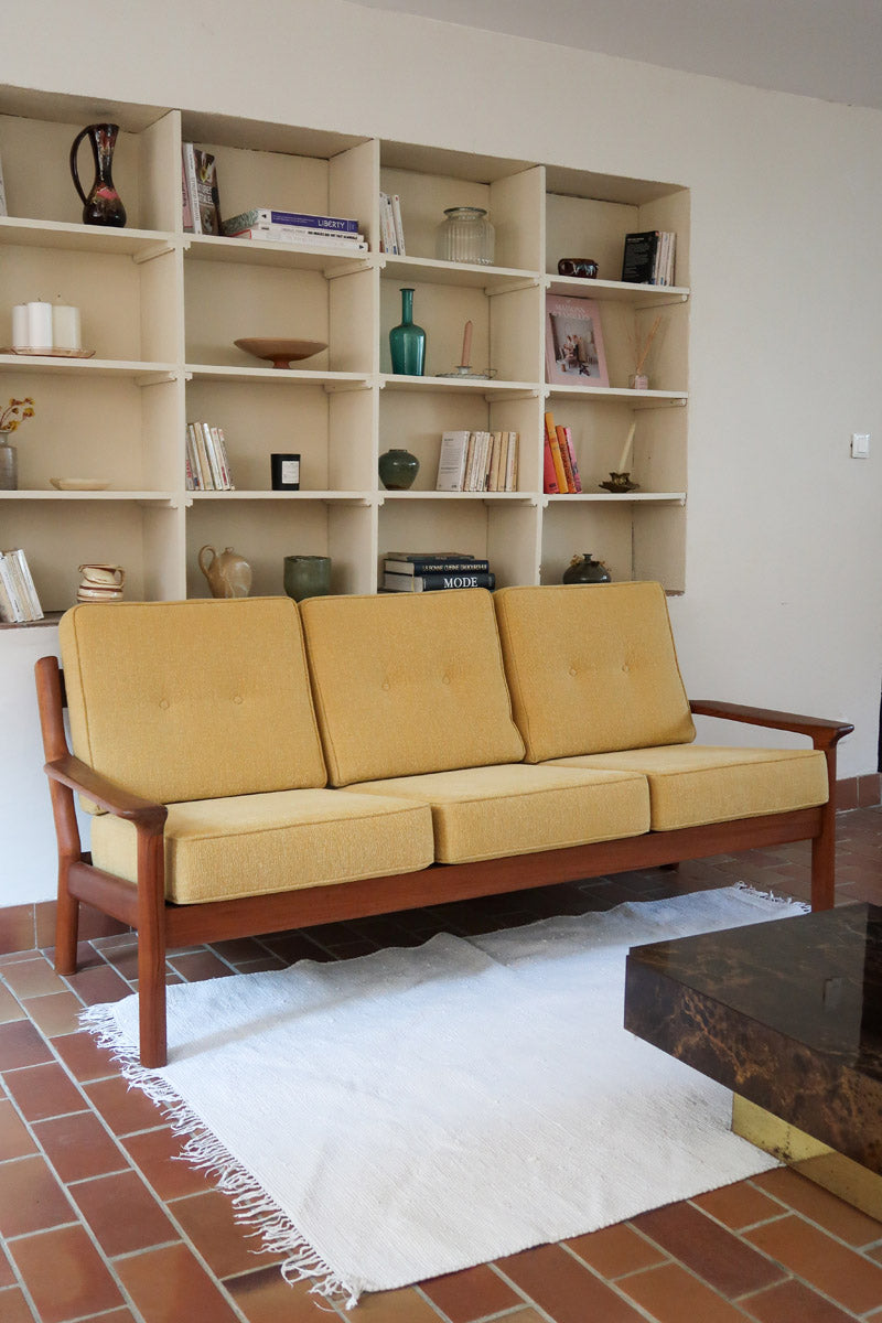 Canapé 3 places scandinave en teck des années 60 avec coussins en tissu jaune moutarde et structure type banquette.