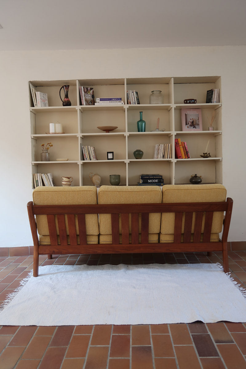 Canapé 3 places scandinave en teck des années 60 avec coussins en tissu jaune moutarde et structure type banquette.