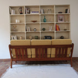 Canapé 3 places scandinave en teck des années 60 avec coussins en tissu jaune moutarde et structure type banquette.