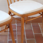 Paire de chaises vintage en hêtre massif des années 60 avec assise en tissu bouclette clair, design Antonín Šuman pour Tatra Nabytok, présentées seules et en mise en situation.