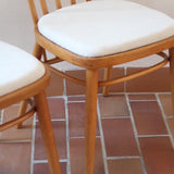 Paire de chaises vintage en hêtre massif des années 60 avec assise en tissu bouclette clair, design Antonín Šuman pour Tatra Nabytok, présentées seules et en mise en situation.