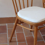 Paire de chaises vintage en hêtre massif des années 60 avec assise en tissu bouclette clair, design Antonín Šuman pour Tatra Nabytok, présentées seules et en mise en situation.