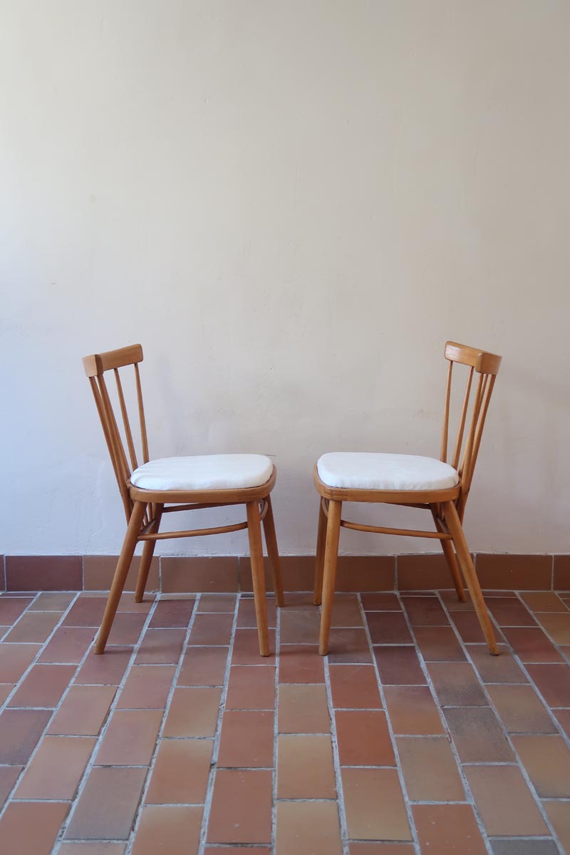 Paire de chaises vintage en hêtre massif des années 60 avec assise en tissu bouclette clair, design Antonín Šuman pour Tatra Nabytok, présentées seules et en mise en situation.