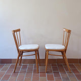 Paire de chaises vintage en hêtre massif des années 60 avec assise en tissu bouclette clair, design Antonín Šuman pour Tatra Nabytok, présentées seules et en mise en situation.