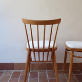 Paire de chaises vintage en hêtre massif des années 60 avec assise en tissu bouclette clair, design Antonín Šuman pour Tatra Nabytok, présentées seules et en mise en situation.