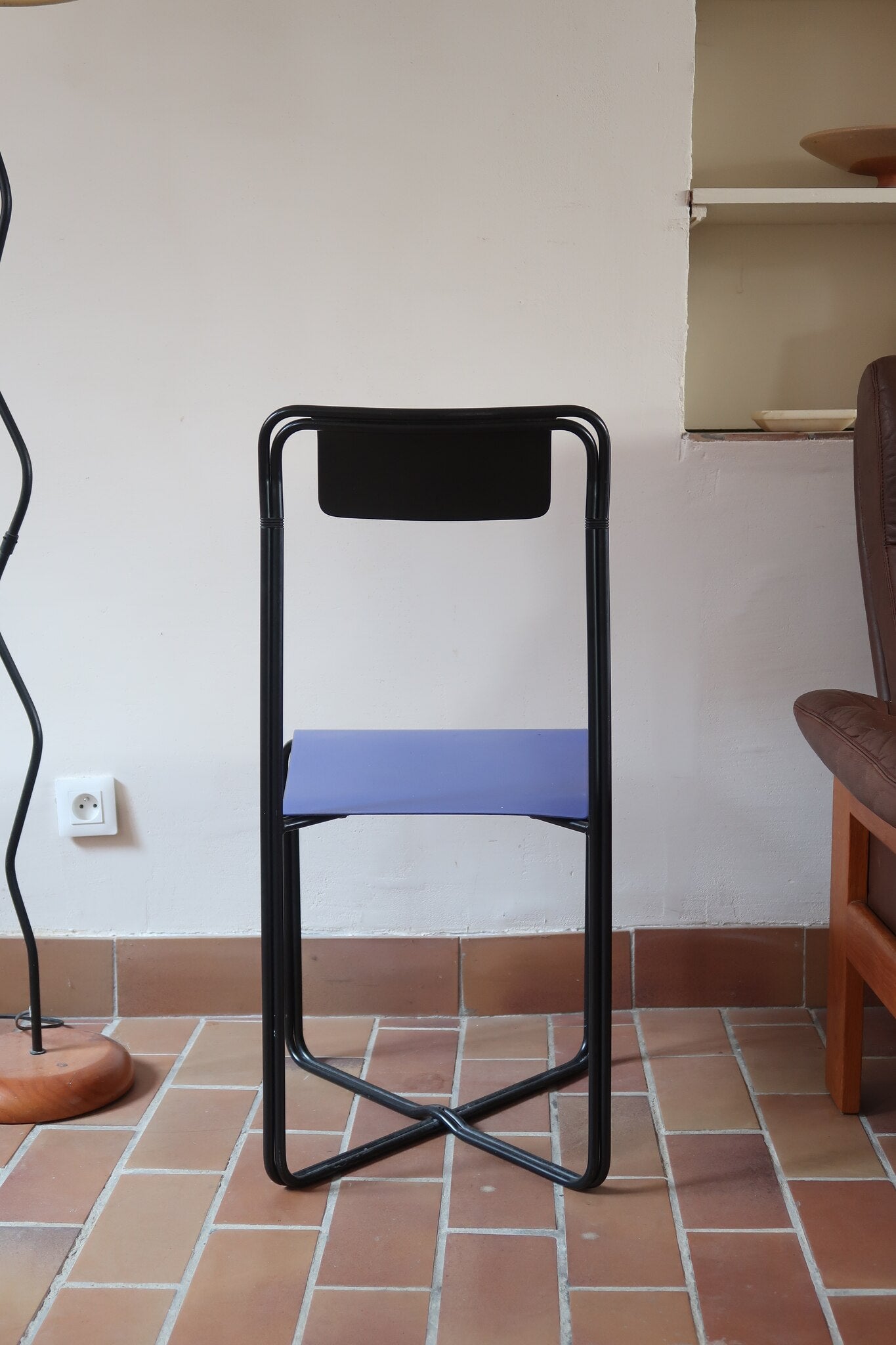 Chaise Kaa vintage par Francesco Soro années 80, tube d'acier laqué noir cintré d'un seul trait formant piétement et dossier, traverse en X au sol, assise en métal laqué bleu outremer