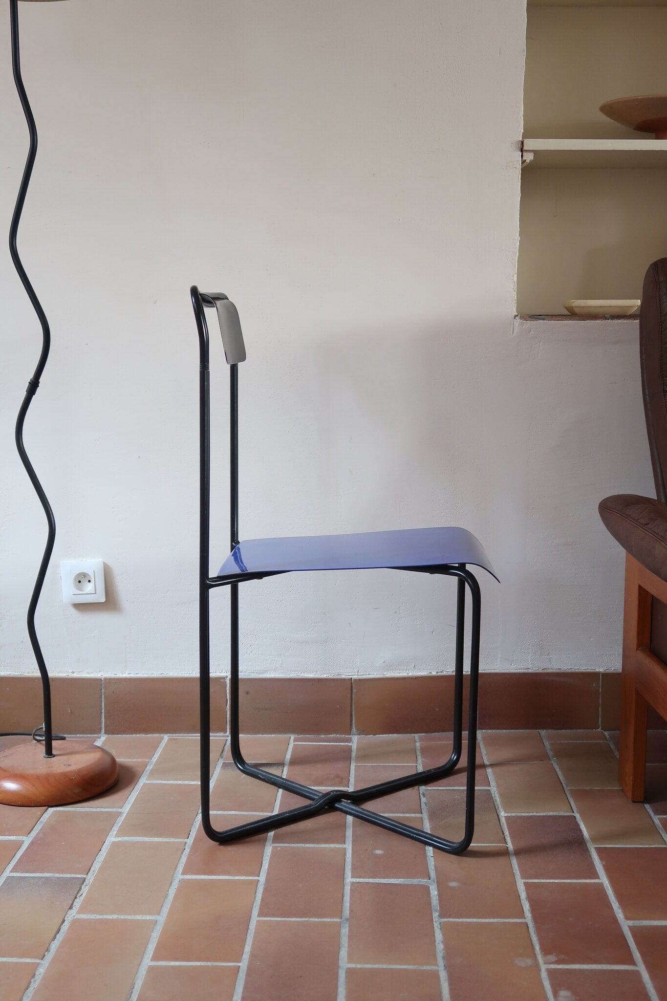 Chaise Kaa vintage par Francesco Soro années 80, tube d'acier laqué noir cintré d'un seul trait formant piétement et dossier, traverse en X au sol, assise en métal laqué bleu outremer