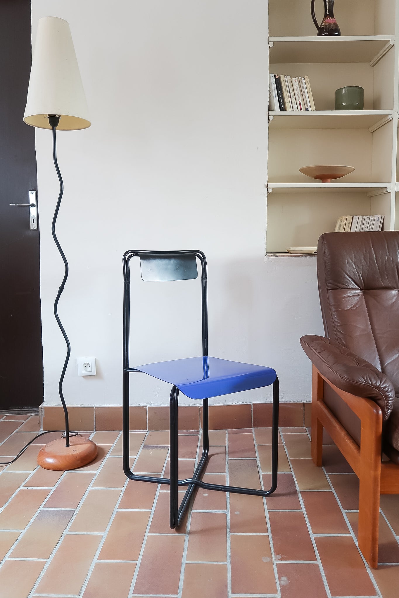 Chaise Kaa vintage par Francesco Soro années 80, tube d'acier laqué noir cintré d'un seul trait formant piétement et dossier, traverse en X au sol, assise en métal laqué bleu outremer