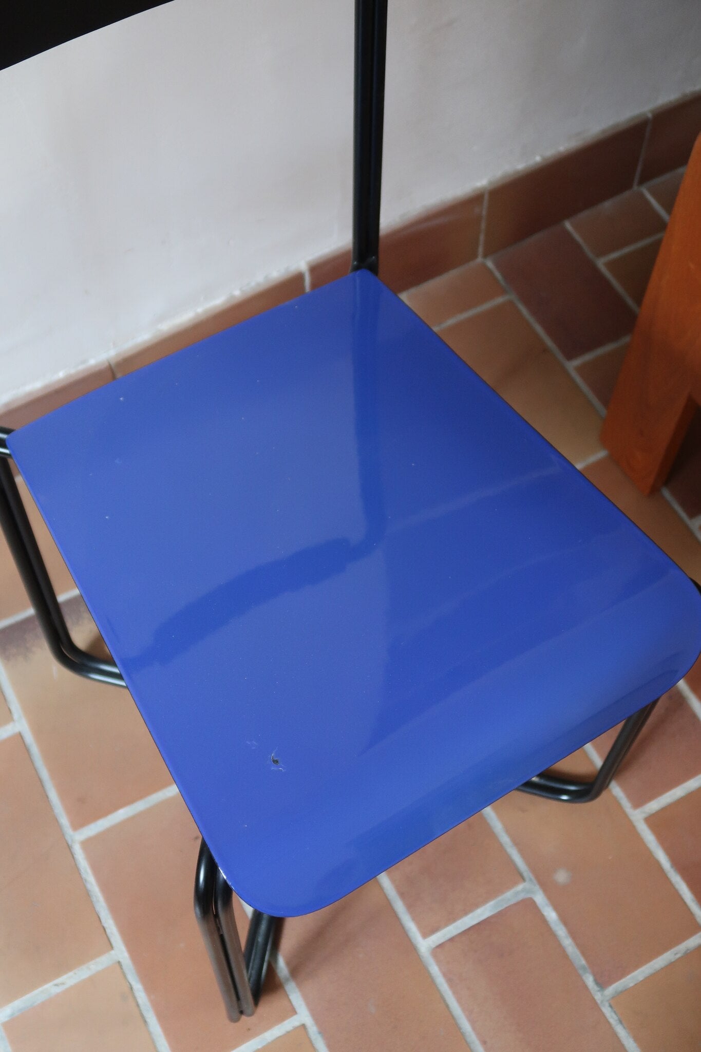 Chaise Kaa vintage par Francesco Soro années 80, tube d'acier laqué noir cintré d'un seul trait formant piétement et dossier, traverse en X au sol, assise en métal laqué bleu outremer