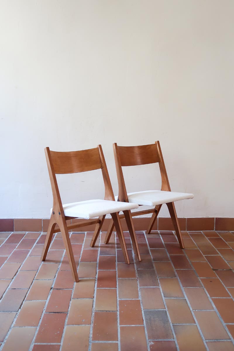 Deux chaises vintage en hêtre massif des années 50 avec assise en tissu bouclette clair, design épuré à la René-Jean Caillette, présentées seules et en mise en situation.
