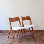 Deux chaises vintage en hêtre massif des années 50 avec assise en tissu bouclette clair, design épuré à la René-Jean Caillette, présentées seules et en mise en situation.