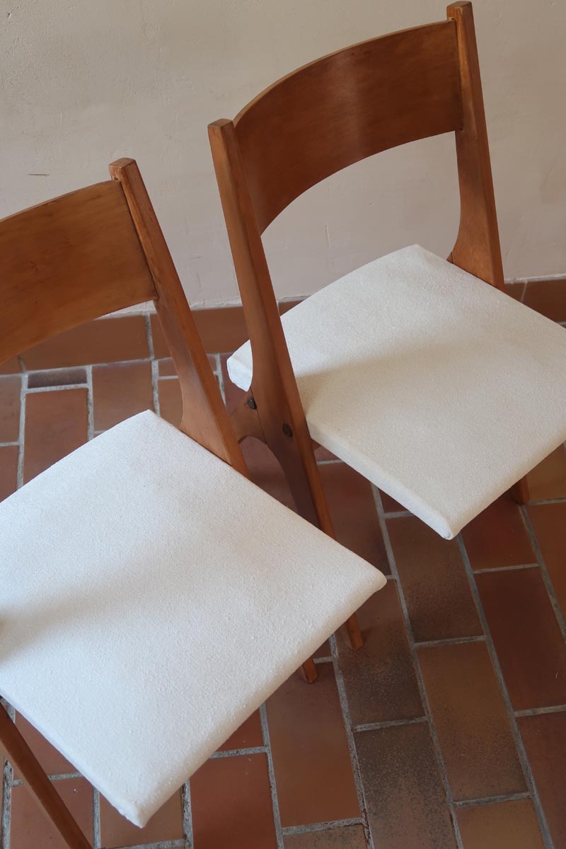 Deux chaises vintage en hêtre massif des années 50 avec assise en tissu bouclette clair, design épuré à la René-Jean Caillette, présentées seules et en mise en situation.