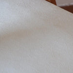 Deux chaises vintage en hêtre massif des années 50 avec assise en tissu bouclette clair, design épuré à la René-Jean Caillette, présentées seules et en mise en situation.