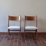 Deux chaises vintage en hêtre massif des années 50 avec assise en tissu bouclette clair, design épuré à la René-Jean Caillette, présentées seules et en mise en situation.