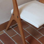 Deux chaises vintage en hêtre massif des années 50 avec assise en tissu bouclette clair, design épuré à la René-Jean Caillette, présentées seules et en mise en situation.