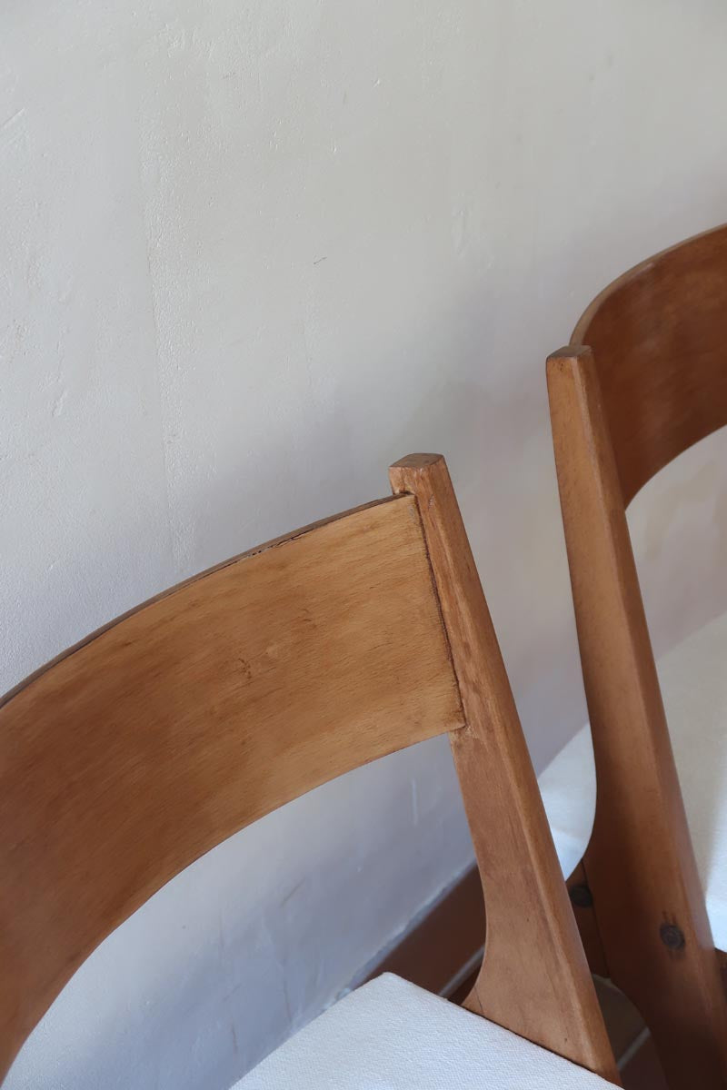 Deux chaises vintage en hêtre massif des années 50 avec assise en tissu bouclette clair, design épuré à la René-Jean Caillette, présentées seules et en mise en situation.