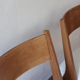 Deux chaises vintage en hêtre massif des années 50 avec assise en tissu bouclette clair, design épuré à la René-Jean Caillette, présentées seules et en mise en situation.