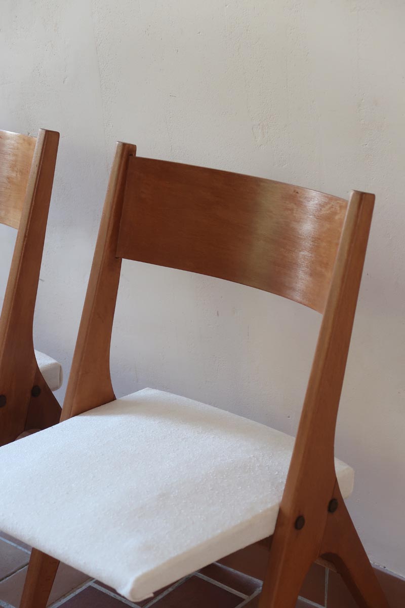Deux chaises vintage en hêtre massif des années 50 avec assise en tissu bouclette clair, design épuré à la René-Jean Caillette, présentées seules et en mise en situation.