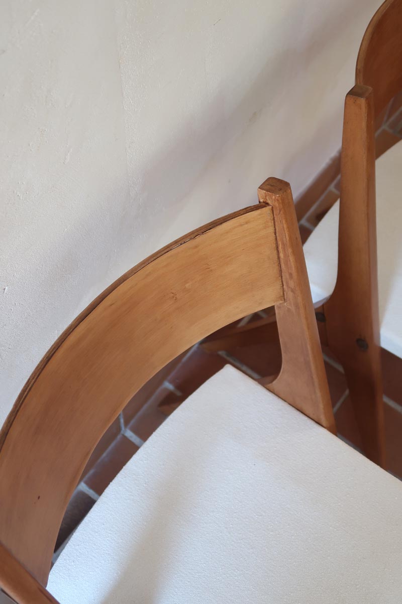 Deux chaises vintage en hêtre massif des années 50 avec assise en tissu bouclette clair, design épuré à la René-Jean Caillette, présentées seules et en mise en situation.