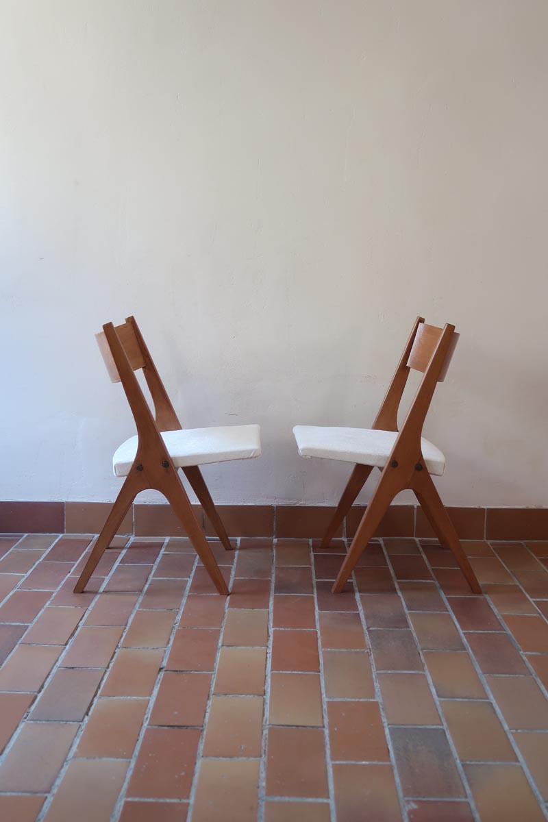 Deux chaises vintage en hêtre massif des années 50 avec assise en tissu bouclette clair, design épuré à la René-Jean Caillette, présentées seules et en mise en situation.