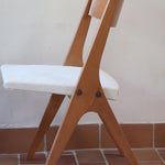 Deux chaises vintage en hêtre massif des années 50 avec assise en tissu bouclette clair, design épuré à la René-Jean Caillette, présentées seules et en mise en situation.