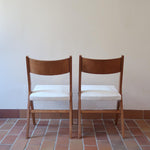 Deux chaises vintage en hêtre massif des années 50 avec assise en tissu bouclette clair, design épuré à la René-Jean Caillette, présentées seules et en mise en situation.