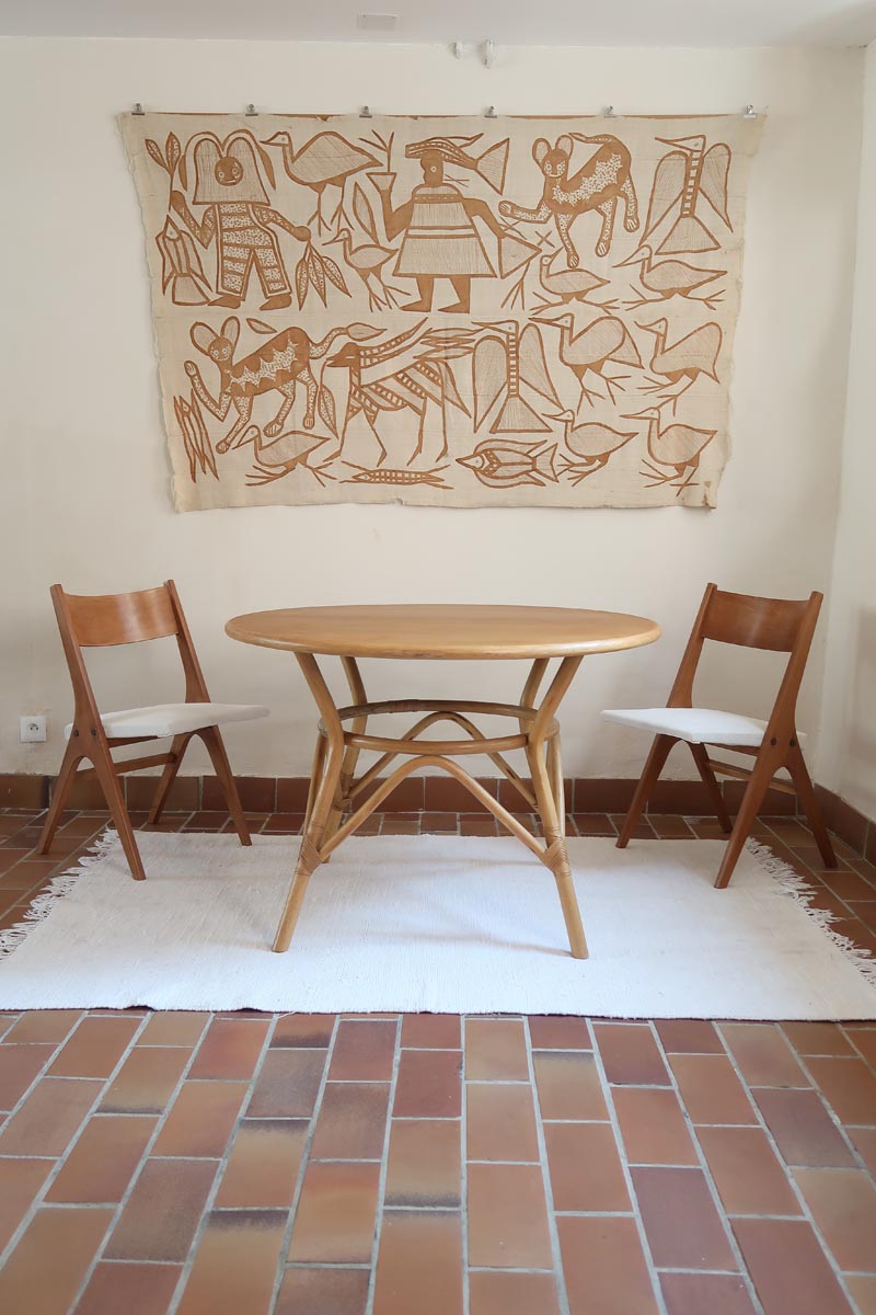 Deux chaises vintage en hêtre massif des années 50 avec assise en tissu bouclette clair, design épuré à la René-Jean Caillette, présentées seules et en mise en situation.